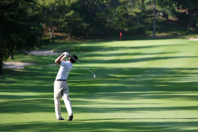 Golfer lining up a shot on a lush fairway