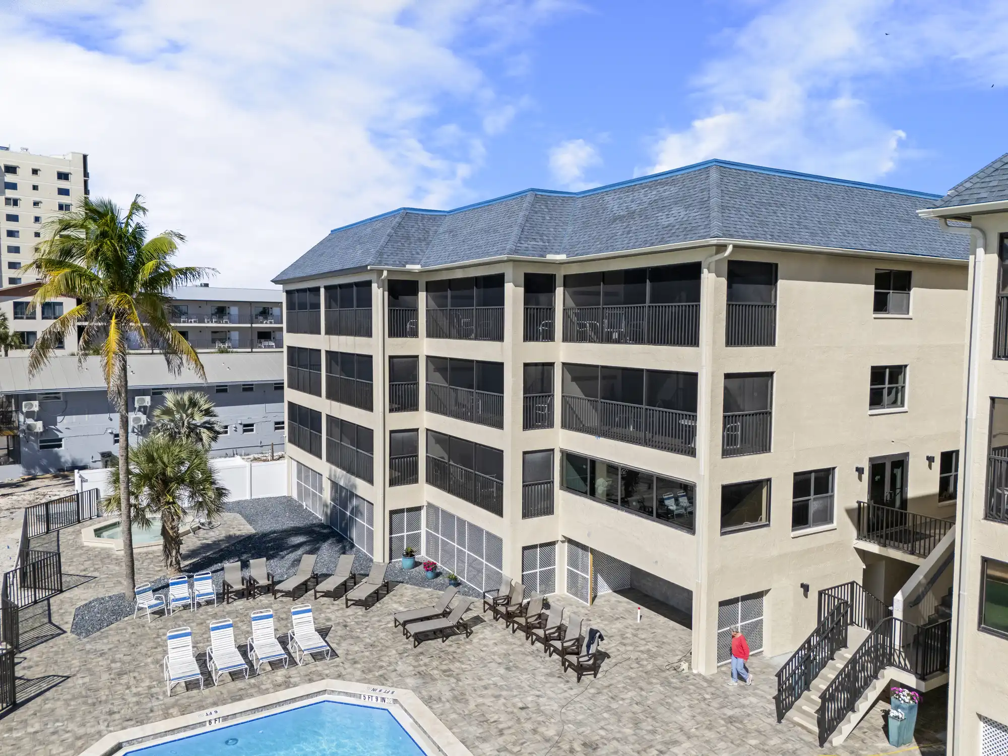 Resort exterior and pool deck with lounge chairs beside a multi-story building