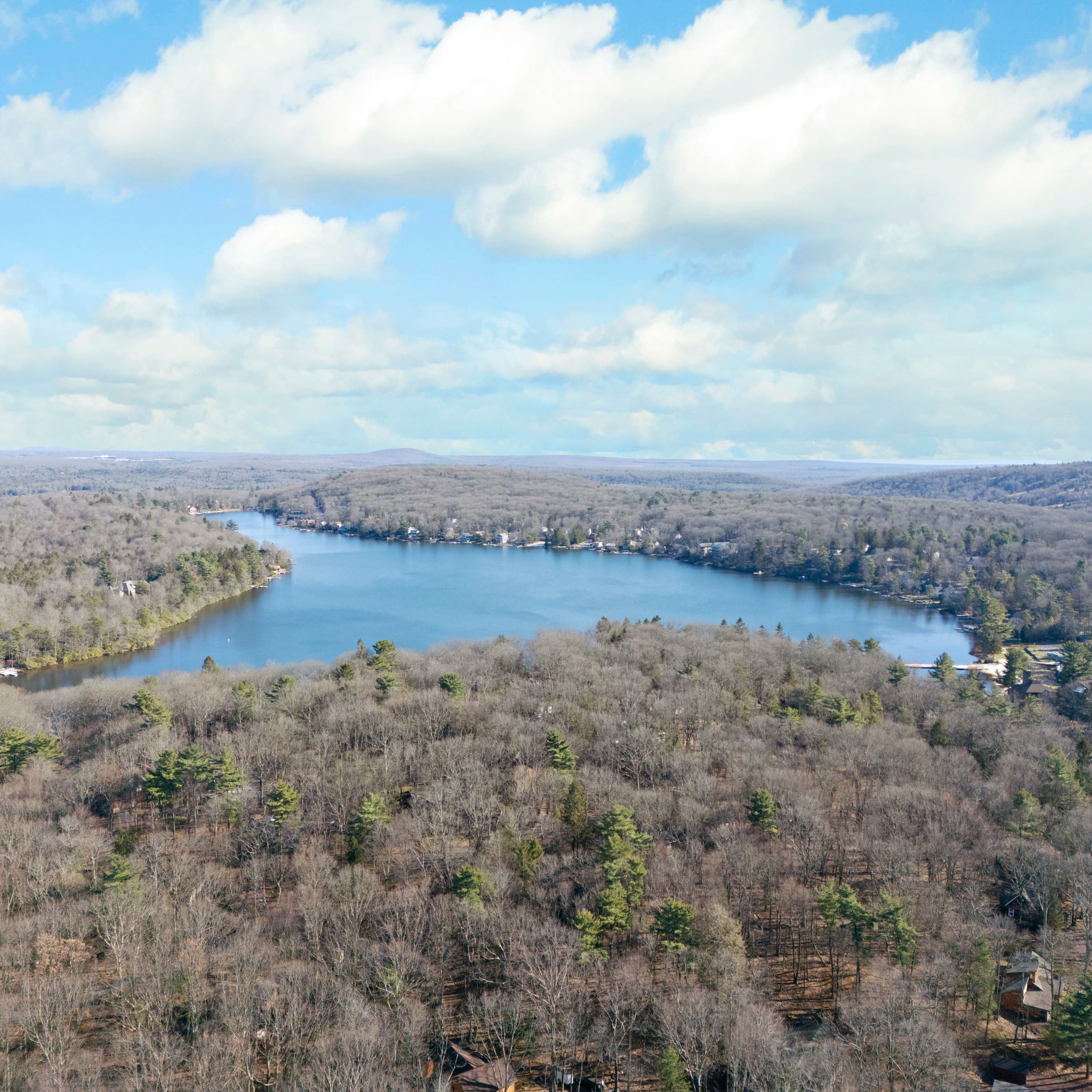 Entrance to Westwood Guest Services featuring a large wooden sign, American flag, and small service cabin surrounded by trees.